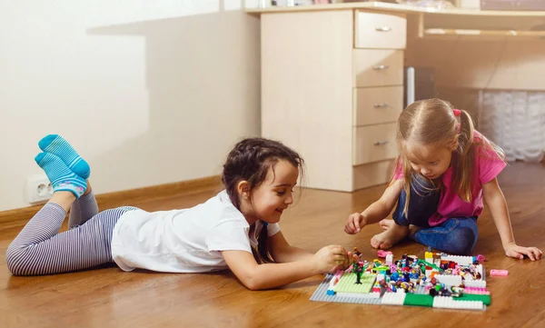 自宅で設定されたエレクターで遊ぶ2人の小さな女の子 — ストック写真