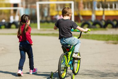 Kids riding bicycles in summer park