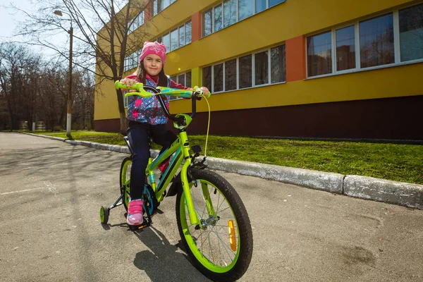 Sorrindo Menina Andando Bicicleta Redor Edifício — Fotografia de Stock