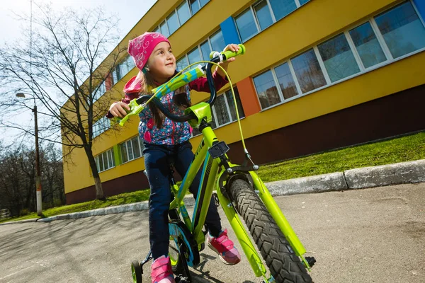 Sorrindo Menina Andando Bicicleta Redor Edifício — Fotografia de Stock