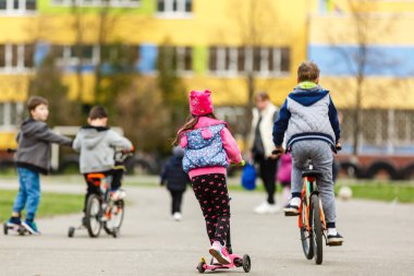 Parkta bisiklet süren çocuklar