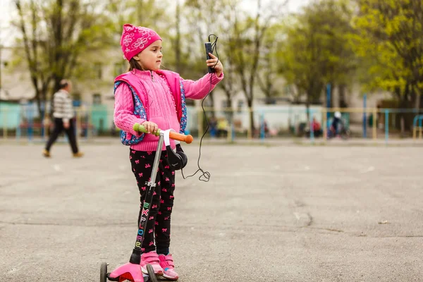 Menina Montando Scooter Com Smartphone Playground — Fotografia de Stock