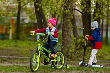 Parkta bisiklet süren çocuklar