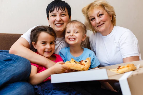 子供を持つ母と祖母は 自宅で大きなピザを食べる — ストック写真