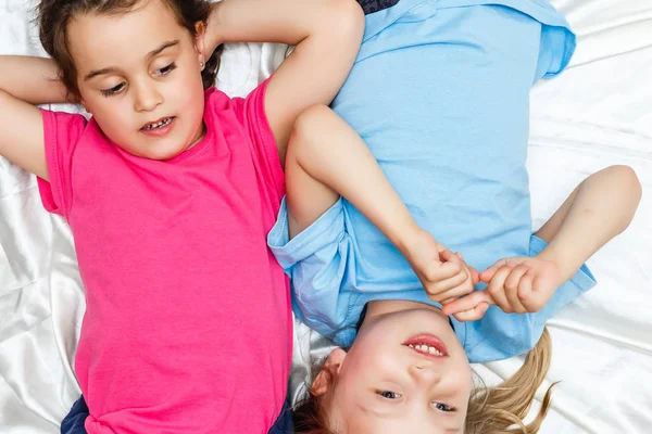 Top Uitzicht Van Gelukkige Kleine Meisjes Liggend Witte Lakens — Stockfoto