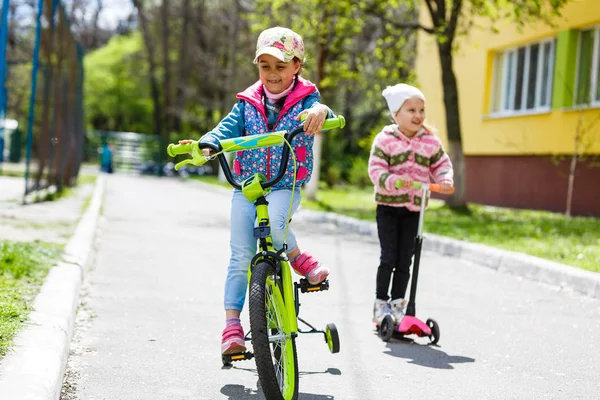Meninas Felizes Andando Scooter Bicicleta Parque Primavera Verde — Fotografia de Stock
