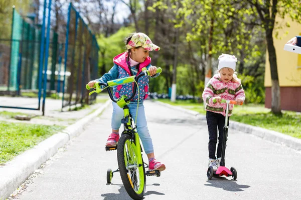 Meninas Felizes Andando Scooter Bicicleta Parque Primavera Verde — Fotografia de Stock