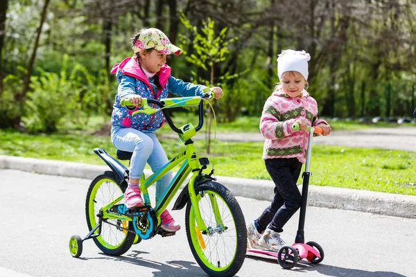 Meninas Felizes Andando Scooter Bicicleta Parque Primavera Verde — Fotografia de Stock