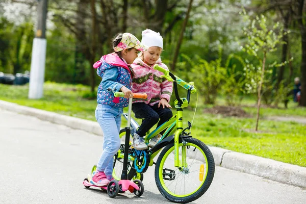 Szczęśliwy Dziewcząt Jazda Konna Skuter Rower Zielony Wiosna Park — Zdjęcie stockowe