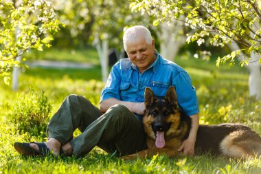 Parkta Alman çoban köpeği yle oturan yaşlı adam