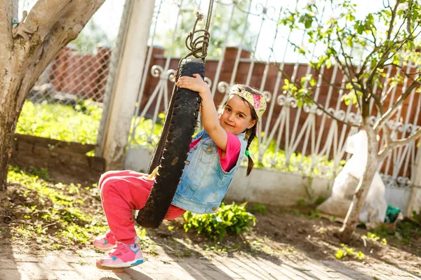 Menina Feliz Balançando Balanço Pneu Jardim Verde — Fotografia de Stock