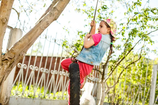 Menina Feliz Balançando Balanço Pneu Jardim Verde — Fotografia de Stock