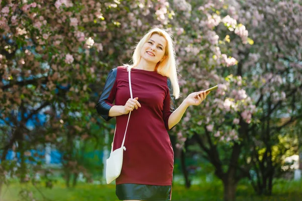 Portret Młodej Kobiety Blondynka Przy Użyciu Smartfona Parku Kwitnące Wiosną — Zdjęcie stockowe