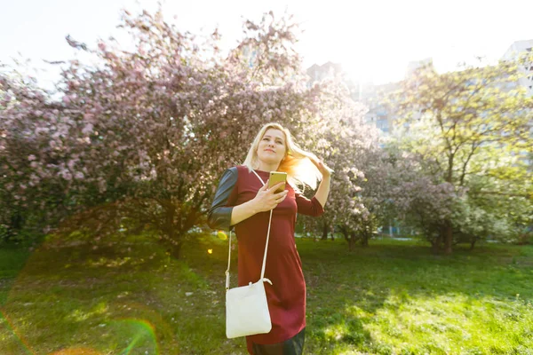 Retrato Jovem Mulher Loira Usando Smartphone Parque Florescendo Primavera — Fotografia de Stock