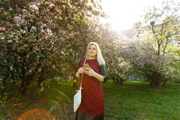 Retrato Mujer Rubia Joven Usando Teléfono Inteligente Parque Floración Primavera — Foto de Stock