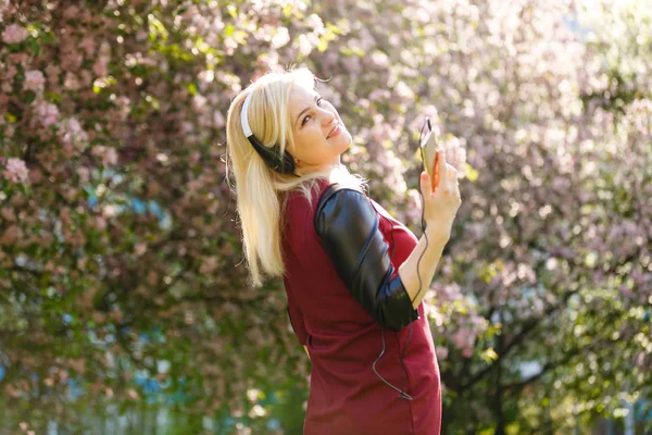 Ung Kvinna Hörlurar Lyssnar Musik Blommande Park — Stockfoto