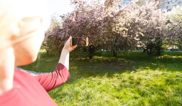 Mujer Rubia Joven Tomando Fotos Del Parque Floreciente — Foto de Stock