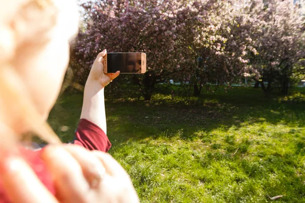 Mujer Rubia Joven Tomando Fotos Del Parque Floreciente — Foto de Stock