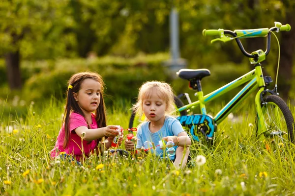 Mädchen Pustet Mit Freundin Seifenblasen Mit Dem Fahrrad — Stockfoto