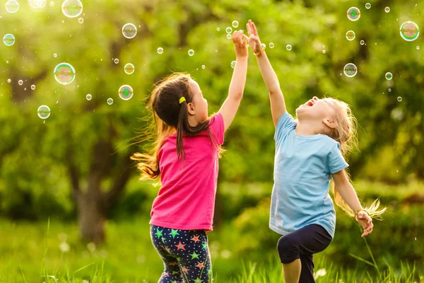 Two Girls Happy Floating Soap Bubbles Green Park Sunset — Stock Photo, Image