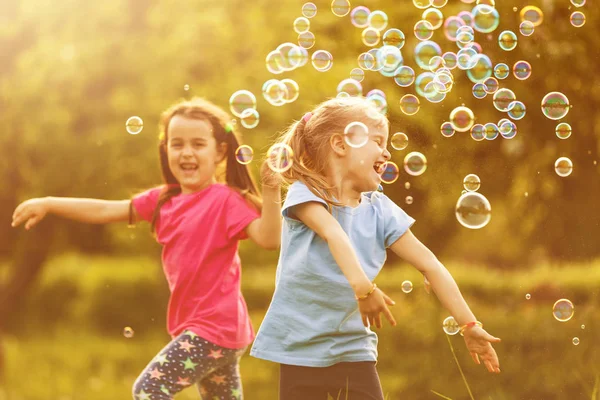 Two Girls Happy Floating Soap Bubbles Green Park Sunset — Stock Photo, Image