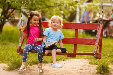 İki küçük kız yeşil park hızıyla eğleniyor