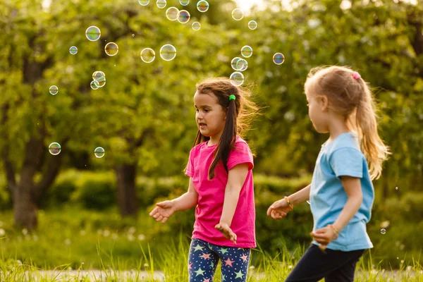 Two Girls Happy Floating Soap Bubbles Green Park Sunset — Stock Photo, Image