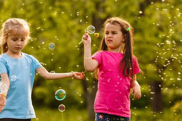 Zwei Mädchen Spielen Grünen Park Und Pusten Schwimmende Seifenblasen — Stockfoto