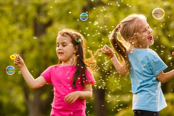 Två Flickor Spelar Gröna Park Och Blåser Flytande Såpbubblor — Stockfoto