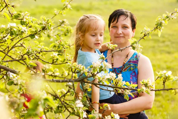 Щаслива Мати Тримає Дочірню Доньку Стоїть Поруч Квітучим Деревом — стокове фото