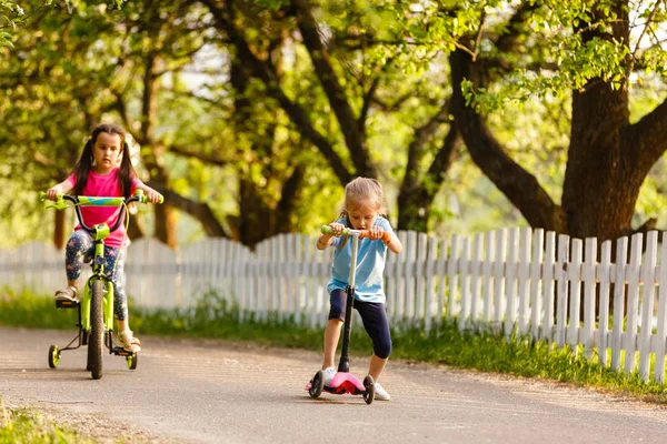 Gelukkige Meisjes Rijden Scooter Fiets Groene Lente Platteland — Stockfoto