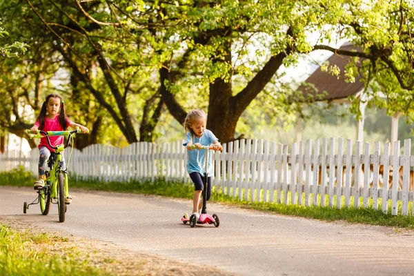 Gelukkige Meisjes Rijden Scooter Fiets Groene Lente Platteland — Stockfoto