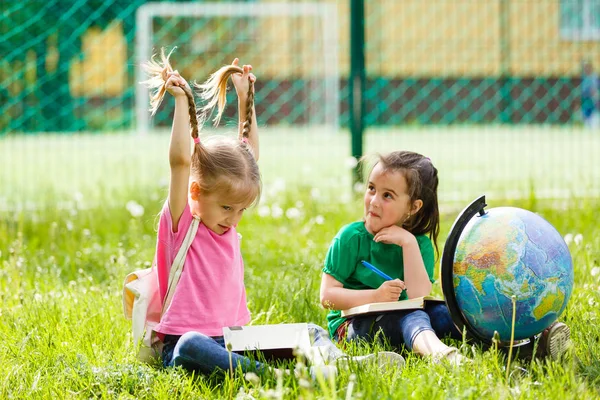Deux Petites Écolières Assises Sur Herbe Avec Globe — Photo