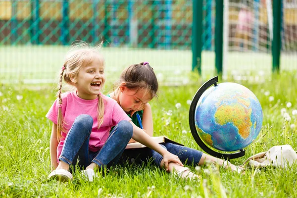 Deux Petites Écolières Assises Sur Herbe Avec Globe — Photo