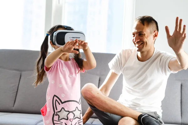Father and daughter playing with virtual reality glasses