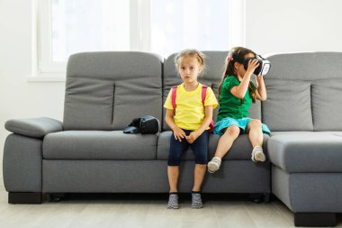 iki küçük kız sanal kullanarak gerçeklik evde oturma odasında gözlükler.