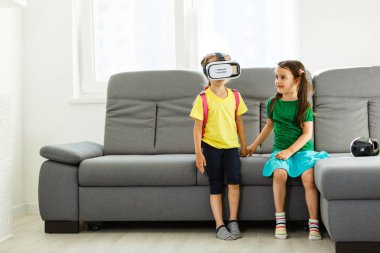 iki küçük kız sanal kullanarak gerçeklik evde oturma odasında gözlükler.