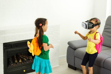 iki küçük kız sanal kullanarak gerçeklik evde oturma odasında gözlükler.