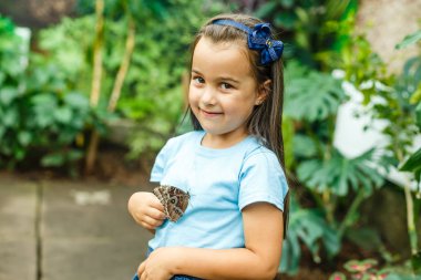 Elinde kelebek tutan kızın yakın görünümü 