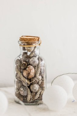 Külahlı cam kavanoz, beyaz arka planda Noel süslemesi.
