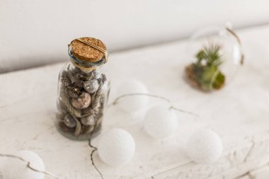 Külahlı cam kavanoz, beyaz arka planda Noel süslemesi.