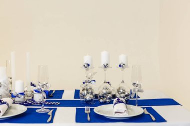 Mavi ve gümüş renklerde Noel dekore akşam yemeği masası 