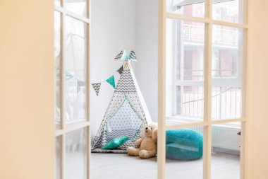 Beyaz odada oyuncak ayı ile Çocuk şık wigwam