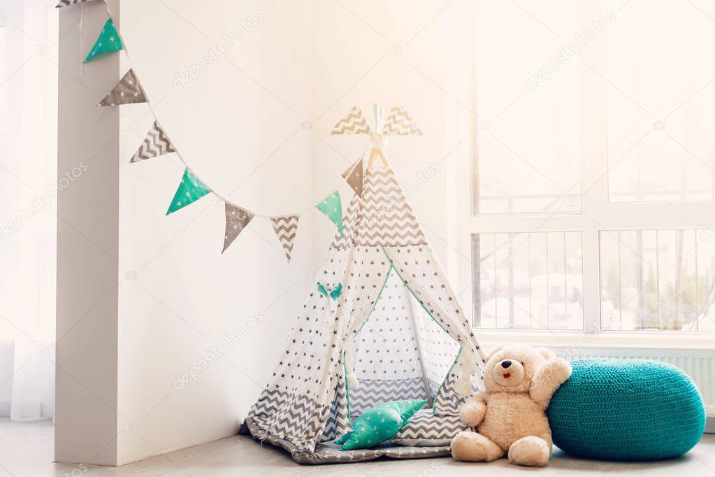 Children stylish wigwam with teddy bear in white room