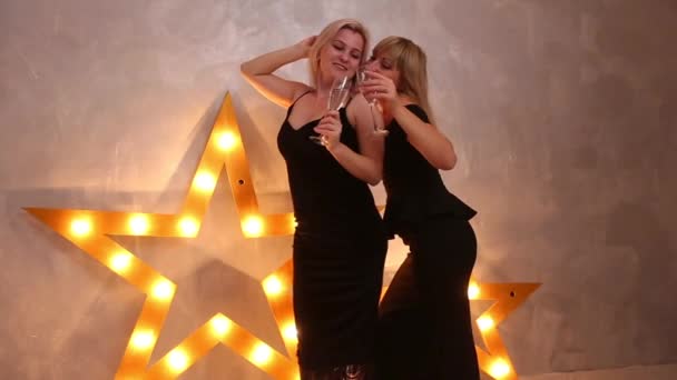 Dwie Eleganckie Kobiety Czarnych Sukienkach Picie Szampana Świecącymi Gwiazdami Tle — Wideo stockowe