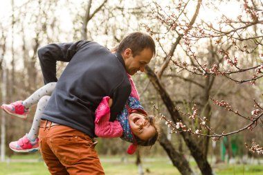 Mutlu kız bahar açan parkta babası ile eğlenmek