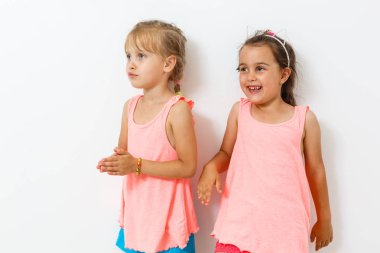 İki küçük kız beyaz arka plan üzerinde poz 