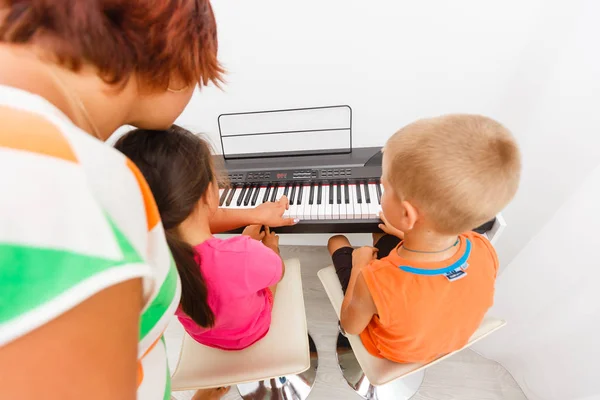 Mujer Joven Tocando Piano Con Niños Pequeños — Foto de Stock