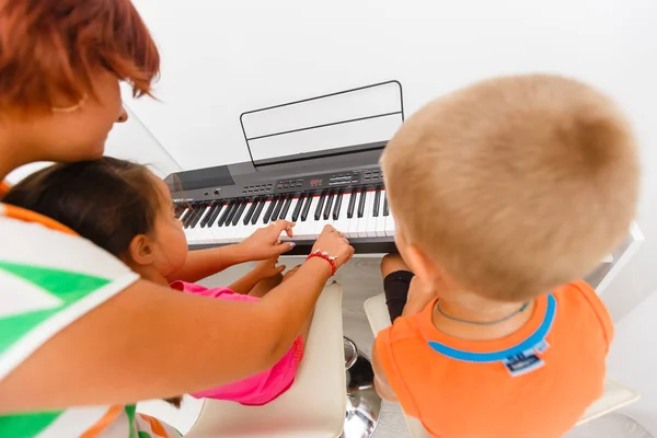 Mujer Joven Tocando Piano Con Niños Pequeños — Foto de Stock