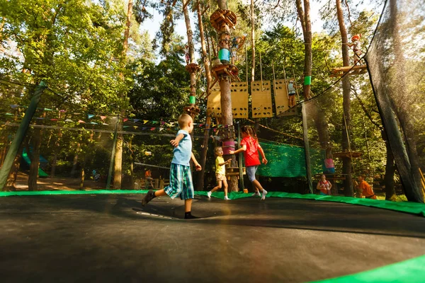 極端な公園でトランポリンに飛び乗る幸せな小さな子供たち — ストック写真